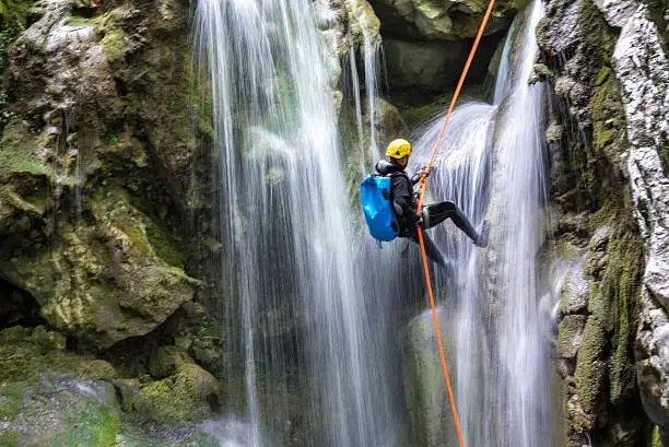 Abenteuerliches Canyoning am Wasserfall Canyoning in der Nähe – Abseilen an einem Wasserfall im Gebirge
